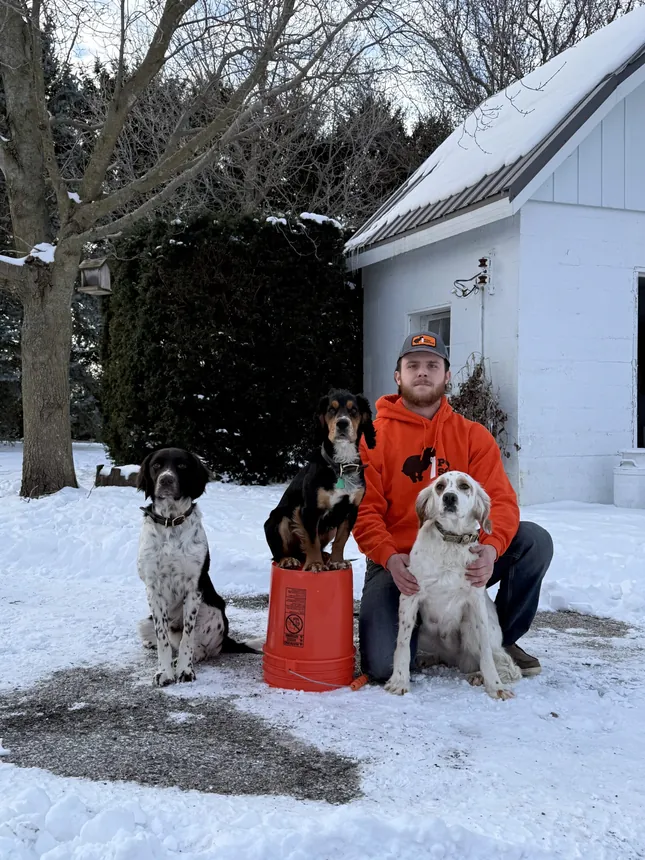 Avian Gerdes, owner of Poo Squad Champaign, with his dogs in the snow